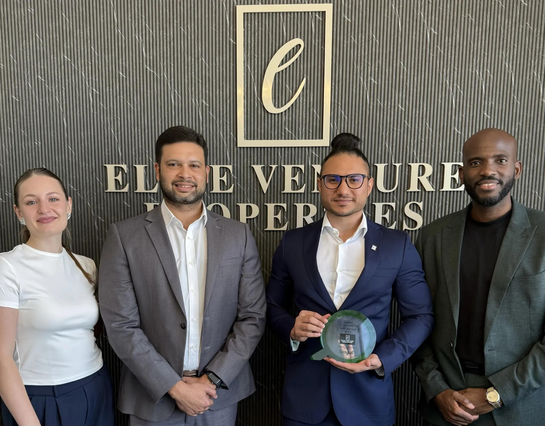 Elite Venture Properties team holding the Bayut Agency of the Quarter award, Dubai Boutique Q3 2026, at the EV office